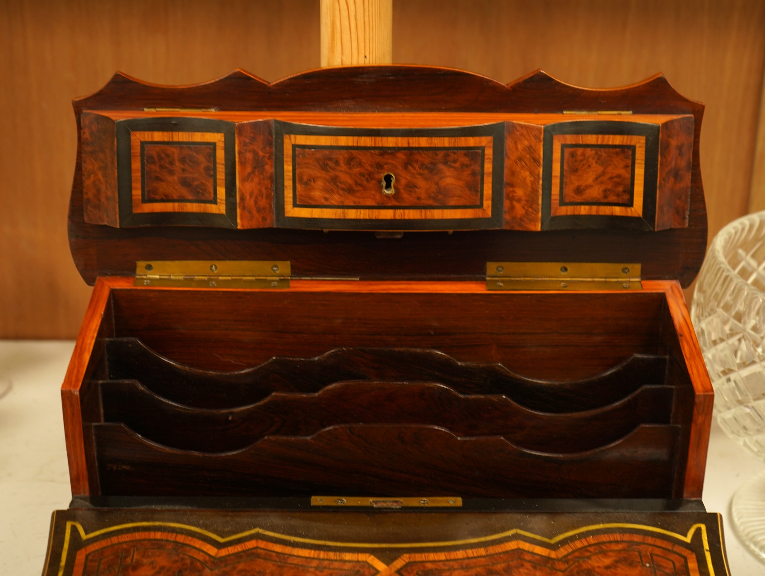 A 19th century French brass inlaid, tulip banded amboyna writing casket, the brass panel inscribed ‘Jane Lester’, 40cm wide